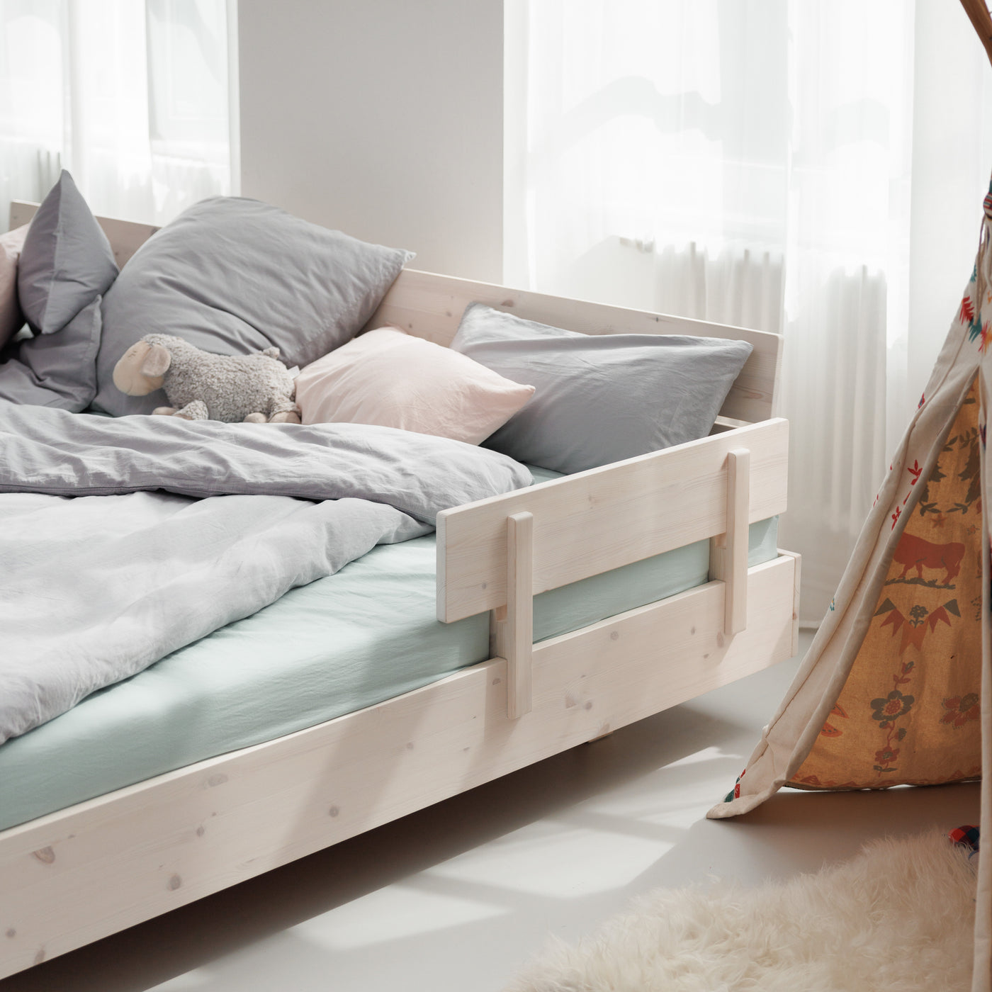 Minimalistisches Familienbett Swebe mit Rausfallschutz aus weiß lasiertem Massivholz und Biobaumwoll-Bettwäsche