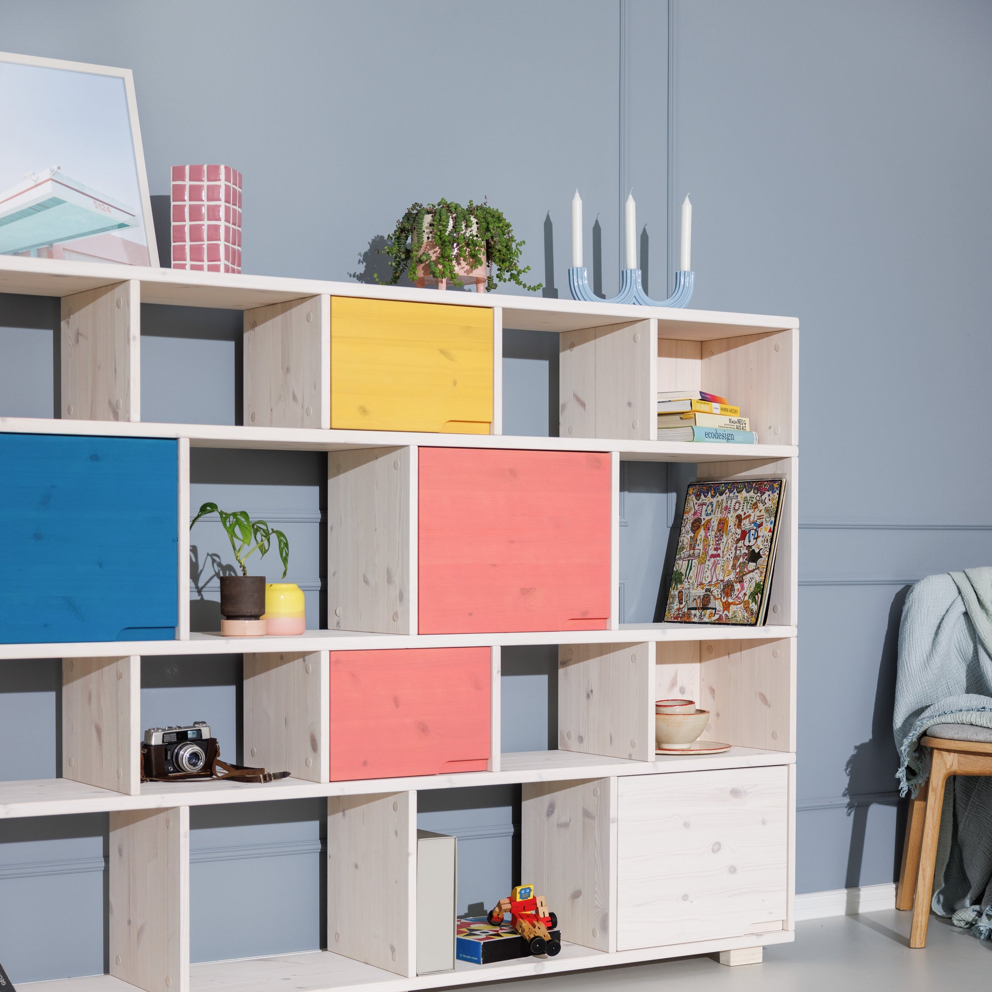 Weißes Bücherregal aus Massivholz mit blauen, roten, gelben Türen