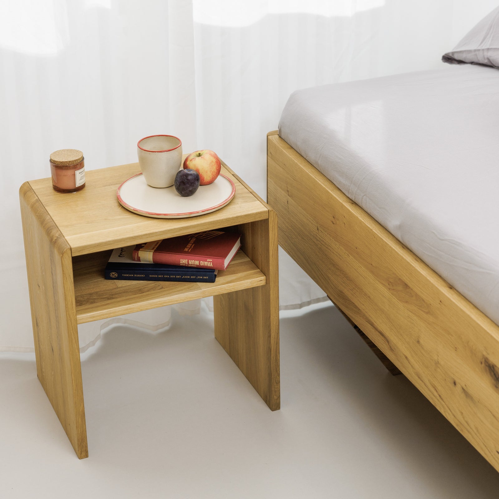 Öko Designer Nachttisch aus robustem Echtholz und funktionaler Ablage neben zeitlosem Schwebebett