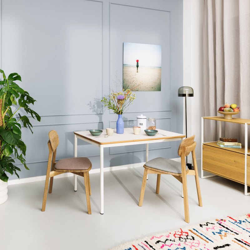 Zeitlose Massivholzstühle, Tisch mit Linoleumplatte und weißen Metallbeinen, kombiniert mit dem Highboard Wega aus Eiche